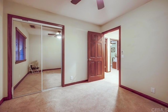 unfurnished bedroom featuring baseboards, a closet, and light carpet