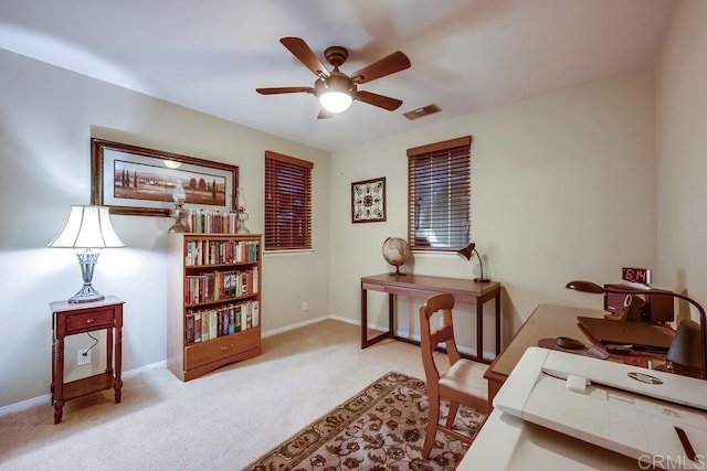 carpeted office space featuring visible vents, baseboards, and ceiling fan