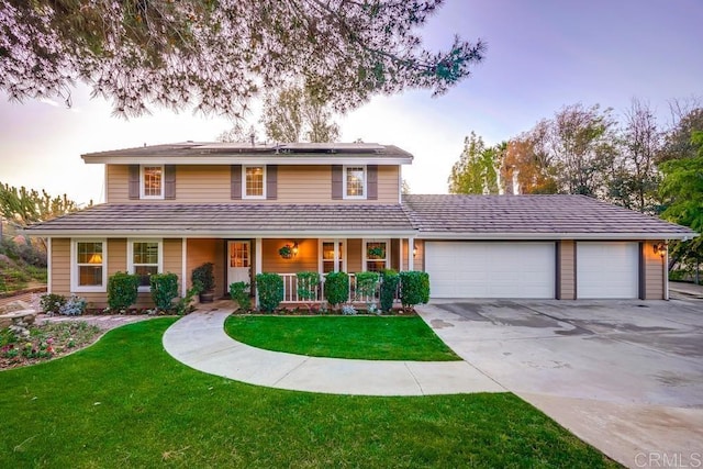 traditional-style house with driveway, a porch, an attached garage, a front lawn, and roof mounted solar panels