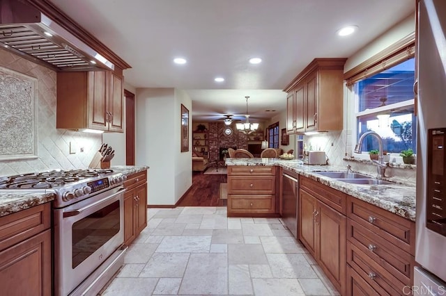 kitchen featuring light stone countertops, recessed lighting, a sink, stainless steel appliances, and custom range hood