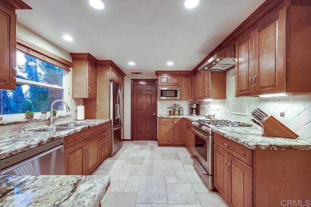 kitchen featuring light stone countertops, recessed lighting, brown cabinets, stainless steel appliances, and a sink