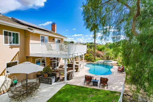 view of pool featuring outdoor dining space, a patio, a yard, and a pool with connected hot tub