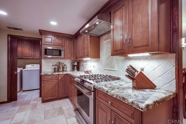 kitchen with wall chimney range hood, brown cabinetry, tasteful backsplash, and appliances with stainless steel finishes