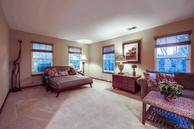 living area featuring visible vents, light colored carpet, and baseboards