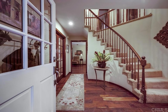 entrance foyer featuring a towering ceiling, recessed lighting, wood finished floors, and stairs