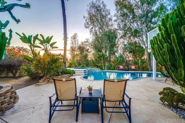 view of pool featuring a patio area, outdoor dining space, and a pool with connected hot tub