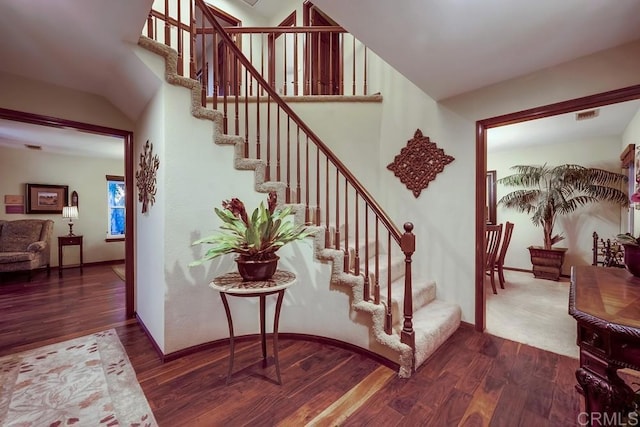 staircase with visible vents, baseboards, and wood finished floors