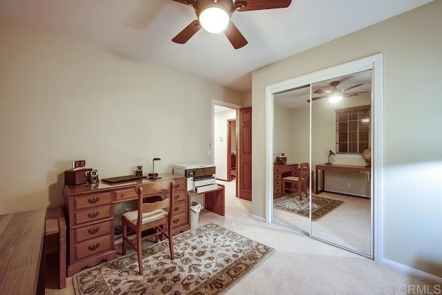 office featuring light colored carpet, baseboards, and ceiling fan