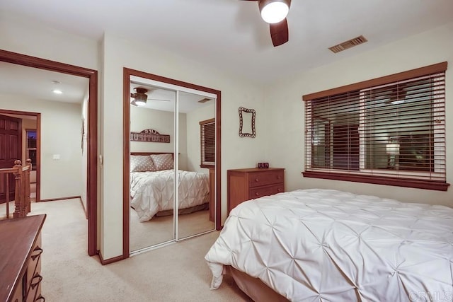 bedroom featuring visible vents, baseboards, ceiling fan, light colored carpet, and a closet