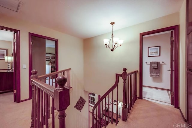 hall featuring an upstairs landing, a chandelier, and light carpet