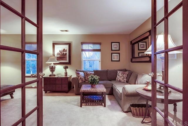 living room featuring visible vents, french doors, and carpet floors