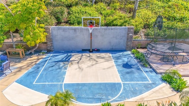 view of sport court with a trampoline, basketball court, and fence