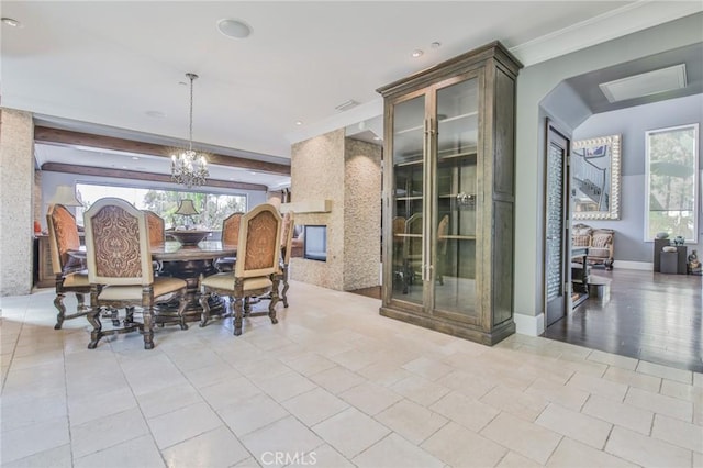 tiled dining area with baseboards, beam ceiling, a healthy amount of sunlight, and a chandelier