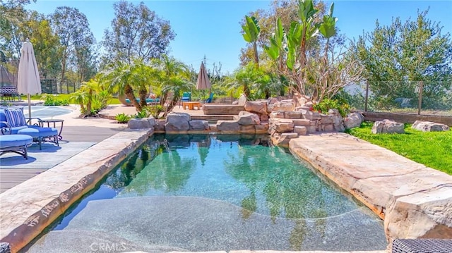 outdoor pool featuring fence and a wooden deck