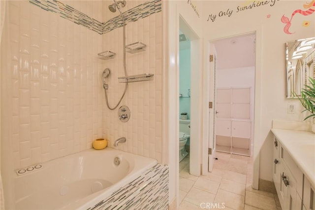 bathroom featuring tile patterned flooring, toilet, vanity, and tiled shower / bath