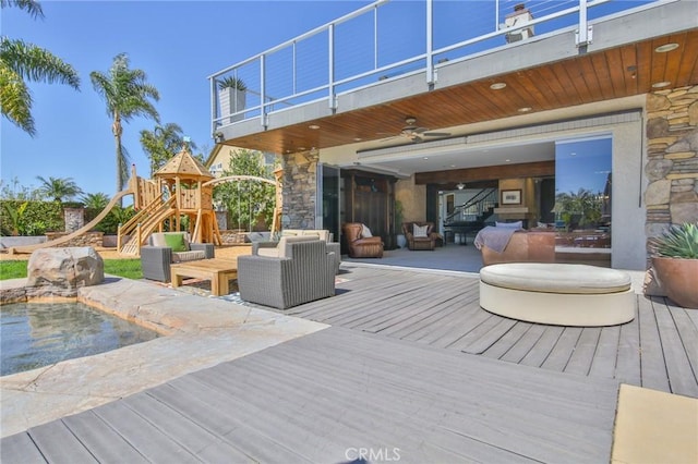 wooden terrace featuring outdoor lounge area, a playground, and a ceiling fan