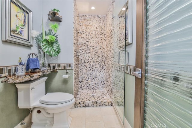 bathroom featuring a shower stall, toilet, and tile patterned floors