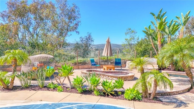 exterior space with a mountain view, a fire pit, and a patio