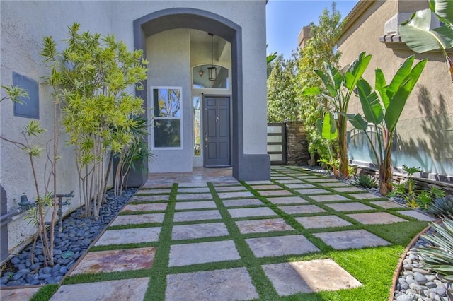 property entrance with fence and stucco siding