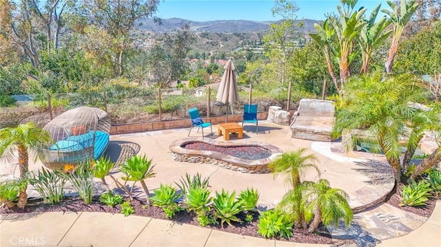 view of patio / terrace with a mountain view and an outdoor fire pit