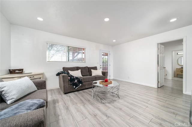 living room featuring recessed lighting, light wood-type flooring, and baseboards