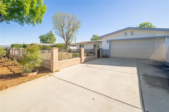 view of front of property featuring a fenced front yard, stucco siding, an attached garage, and concrete driveway