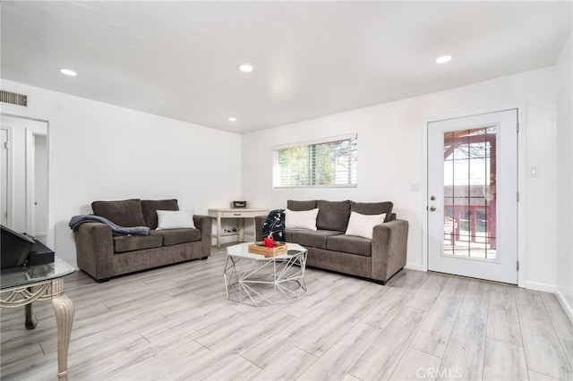 living room featuring recessed lighting, visible vents, a healthy amount of sunlight, and light wood-style floors