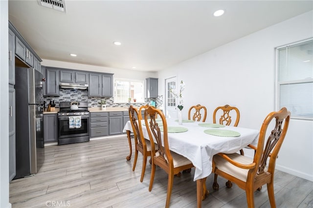 dining room featuring light wood-style flooring, recessed lighting, visible vents, and baseboards