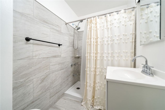 bathroom with vanity and a tile shower