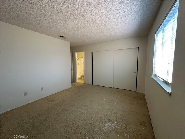 unfurnished bedroom featuring a closet, visible vents, and a textured ceiling