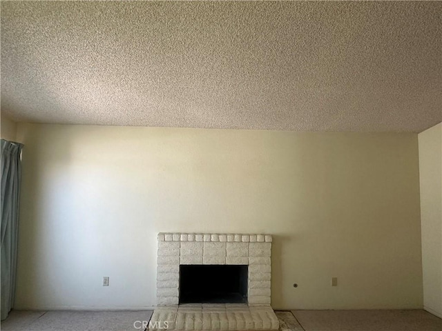 unfurnished living room featuring light colored carpet, a brick fireplace, and a textured ceiling