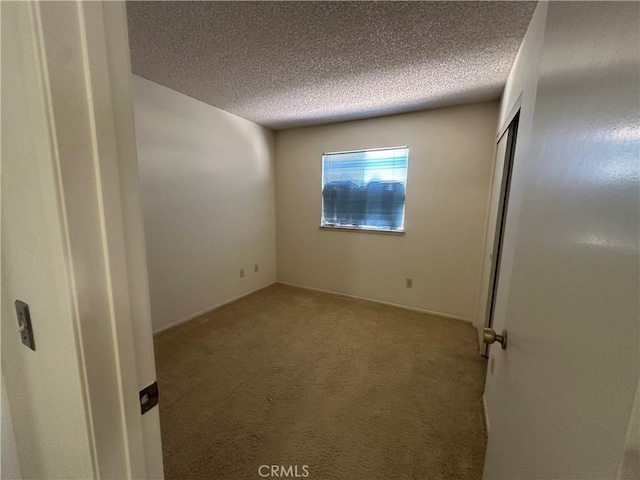 unfurnished bedroom with a closet, carpet floors, and a textured ceiling