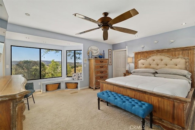 bedroom with light colored carpet, baseboards, and a ceiling fan