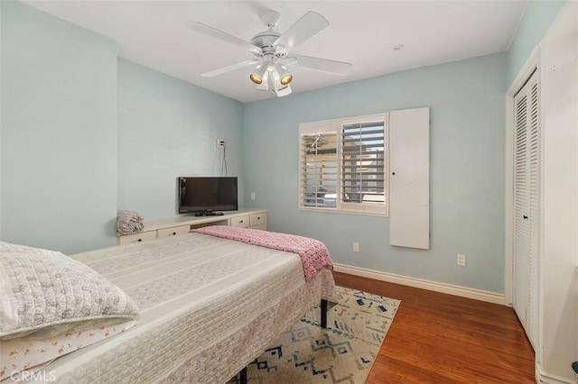 bedroom with wood finished floors, a closet, a ceiling fan, and baseboards