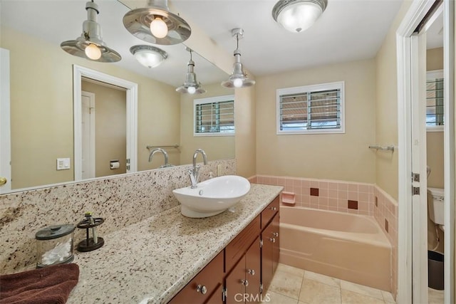bathroom with tile patterned flooring, vanity, a bath, and toilet