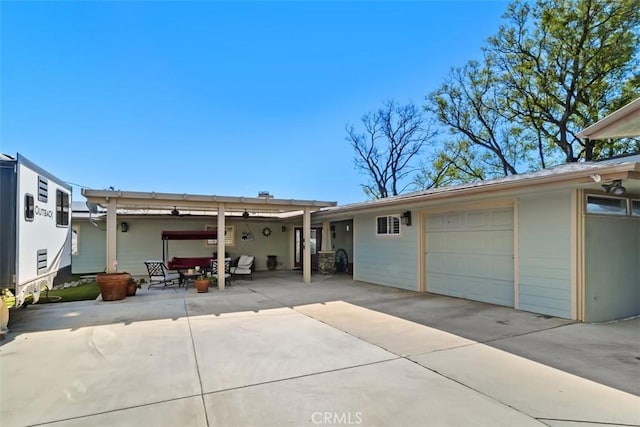 rear view of house with a garage and concrete driveway