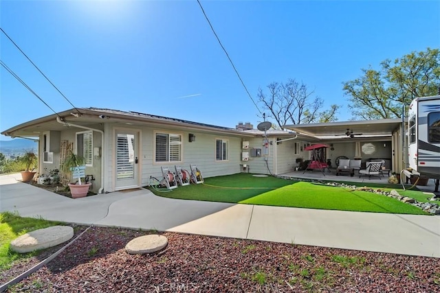 back of house with a patio area, ceiling fan, a yard, and an outdoor living space