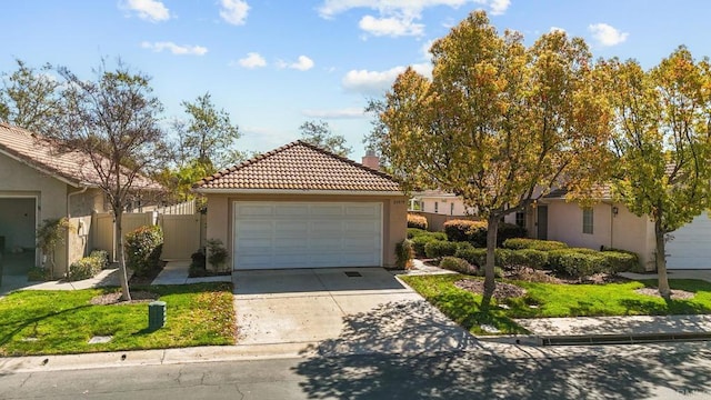 mediterranean / spanish-style house with a tiled roof, fence, a garage, and stucco siding