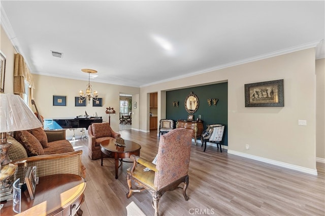 living area featuring crown molding, light wood-type flooring, visible vents, and a chandelier