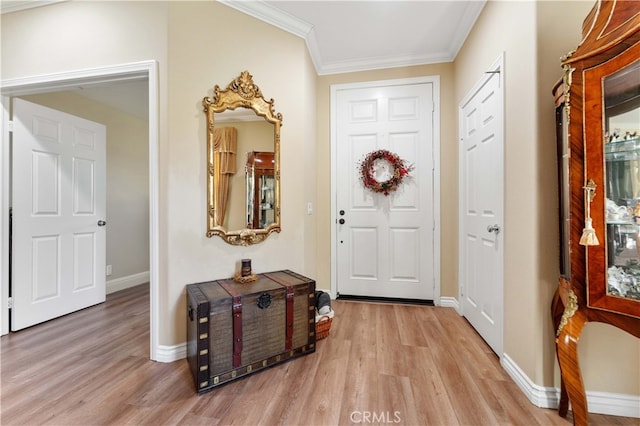 entrance foyer featuring crown molding, light wood-style flooring, and baseboards