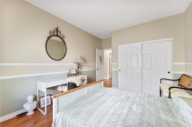 bedroom featuring a closet, baseboards, and wood finished floors