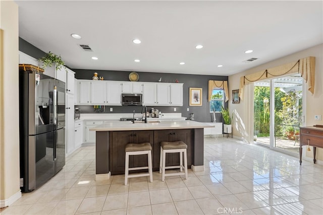 kitchen with white cabinetry, light countertops, visible vents, and stainless steel appliances