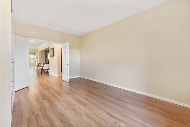 unfurnished room featuring baseboards and light wood-type flooring