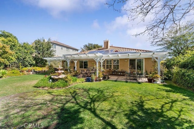 back of property featuring a yard, a pergola, stucco siding, a chimney, and a patio area