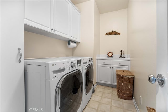 laundry room with washing machine and dryer, cabinet space, baseboards, and light floors