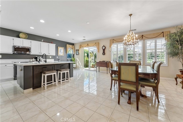 dining room featuring light tile patterned floors, a chandelier, a healthy amount of sunlight, and recessed lighting