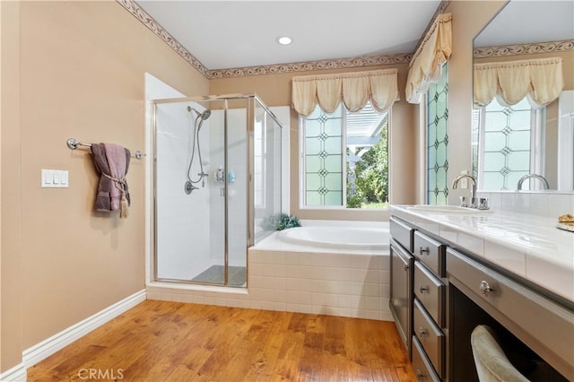 full bathroom with a bath, a stall shower, vanity, and wood finished floors