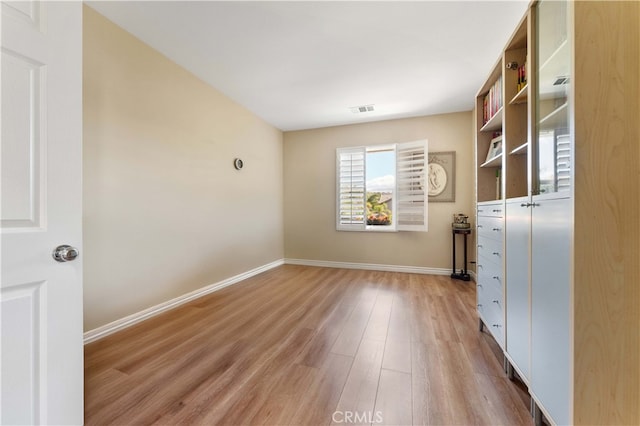 interior space with visible vents, baseboards, and wood finished floors