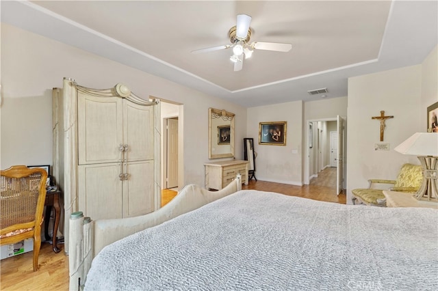 bedroom featuring ceiling fan, visible vents, and light wood-style flooring