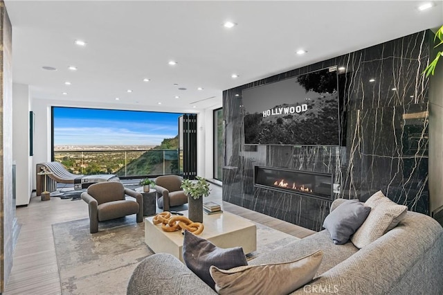 interior space with recessed lighting, wood finished floors, a fireplace, and floor to ceiling windows